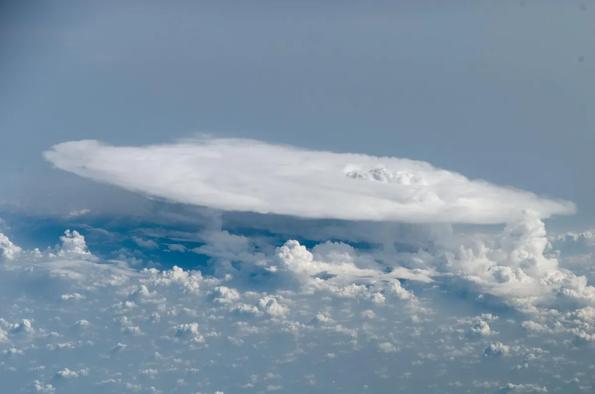 Eine Gewitterwolke von der Internationalen Raumstation aus, ihre flache Oberseite über den kleineren Wolken darunter ausgebreitet
